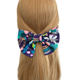 Colorful floral hair bow on a person's head with a white background