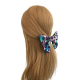 Colorful butterfly hair clip on a mannequin head with brown hair against a white background