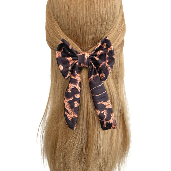 Hair bow with leopard print pattern on a mannequin head with blonde hair.