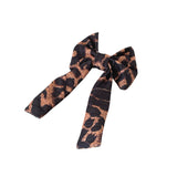 Black and brown patterned bow on a white background