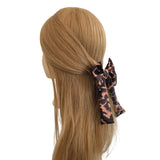 Mannequin head with long blonde hair featuring a patterned hair bow on a white background