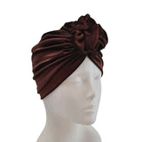 Brown headscarf with a bow on a mannequin head against a white background