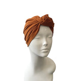 Brown turban on a mannequin head against a white background
