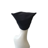 Black headscarf on a white mannequin head against a white background