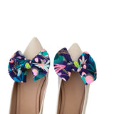 Pair of shoes with floral bow decorations on a white background