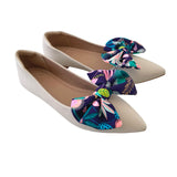 Pair of beige flats with floral bow accents on a white background