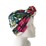 Colorful headscarf with leaf pattern on a mannequin head against a white background