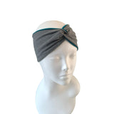 Gray headband with teal trim on a mannequin head against a white background