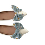 Flats with floral bow details on a white background