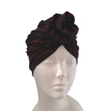 Dark red turban on a mannequin head against a white background ireland