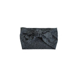 A black fabric headband with a small leopard print pattern and a large front bow, shown flat against a solid white background.