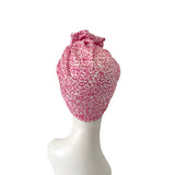 Pink leopard print headscarf on a mannequin head against a white background