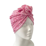 Pink patterned headscarf on a mannequin head against a white background