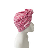 Pink patterned headscarf on a mannequin head against a white background