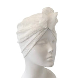 White lace headscarf on a mannequin head against a white background