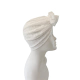 White lace headscarf on a mannequin head against a white background