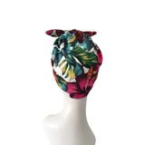 Colorful tropical leaf patterned headscarf on a mannequin head against a white background