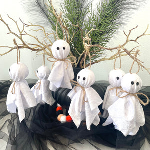 Decorative ghosts on a wreath with greenery and black tulle