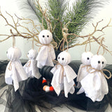 Decorative ghosts on a wreath with greenery and black tulle