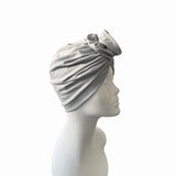 Gray headscarf on a mannequin head against a white background