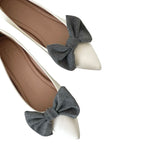 White shoes with gray bow details on a white background