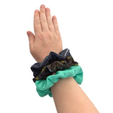 Hand wearing three scrunchies on a white background ireland