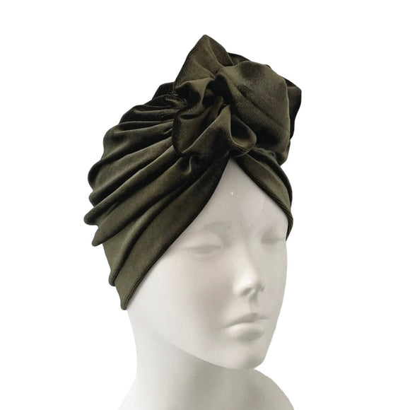 Green turban on a mannequin head against a white background