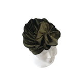 Green velvet turban on a mannequin head against a white background