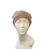 Beige headscarf on a mannequin head against a white background