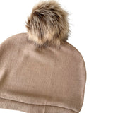 Beige beanie with a fur pom-pom on a white background