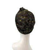 Black headscarf with peacock feather pattern on a mannequin head against a white background