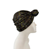 Black turban with feather pattern on a mannequin head against a white background