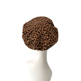 Leopard print beret on a mannequin head against a white background