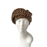Leopard print turban on a mannequin head against a white background