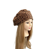 Leopard print beret on a mannequin head with long hair against a white background