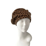 Leopard print headscarf on a mannequin head against a white background