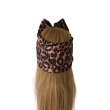 A long blonde wig with a leopard print headband and cat ears, displayed on a mannequin head against a plain white background.