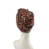 Leopard print headscarf on a mannequin head against a white background