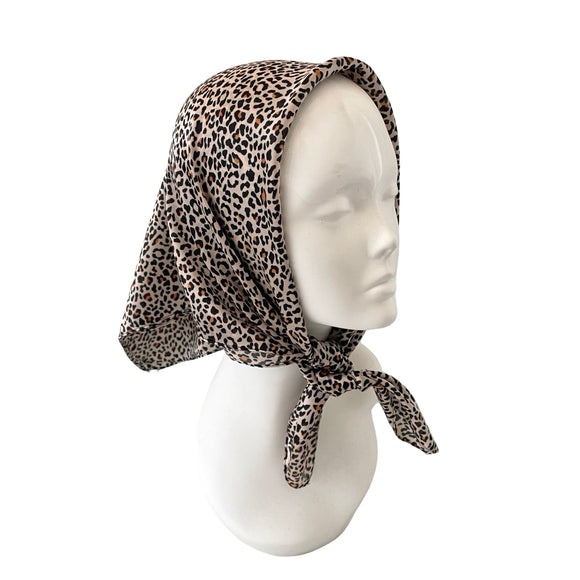 Leopard print headscarf on a mannequin head against a white background