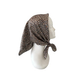 Leopard print headscarf on a mannequin head against a white background