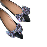 Black shoes with colorful leopard print bows on a white background