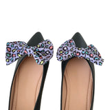 Black shoes with colorful leopard print bows on a white background