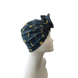 Blue headscarf with gold patterns on a mannequin head against a white background