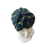 Blue headscarf with yellow patterns on a mannequin head against a white background