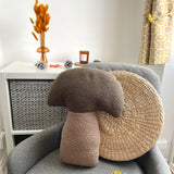 Decorative mushroom-shaped pillow on a chair with a side table and decorative items in the background.