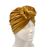 Mustard yellow headscarf on a mannequin head against a white background