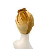 Gold headscarf on a mannequin head against a white background