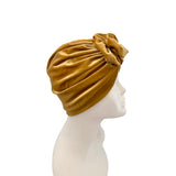 Gold turban on a mannequin head against a white background