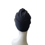 dark blue turban on a white mannequin head against a white background