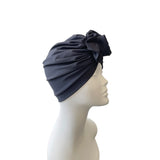 Navy blue headscarf with a bow on a mannequin head against a white background